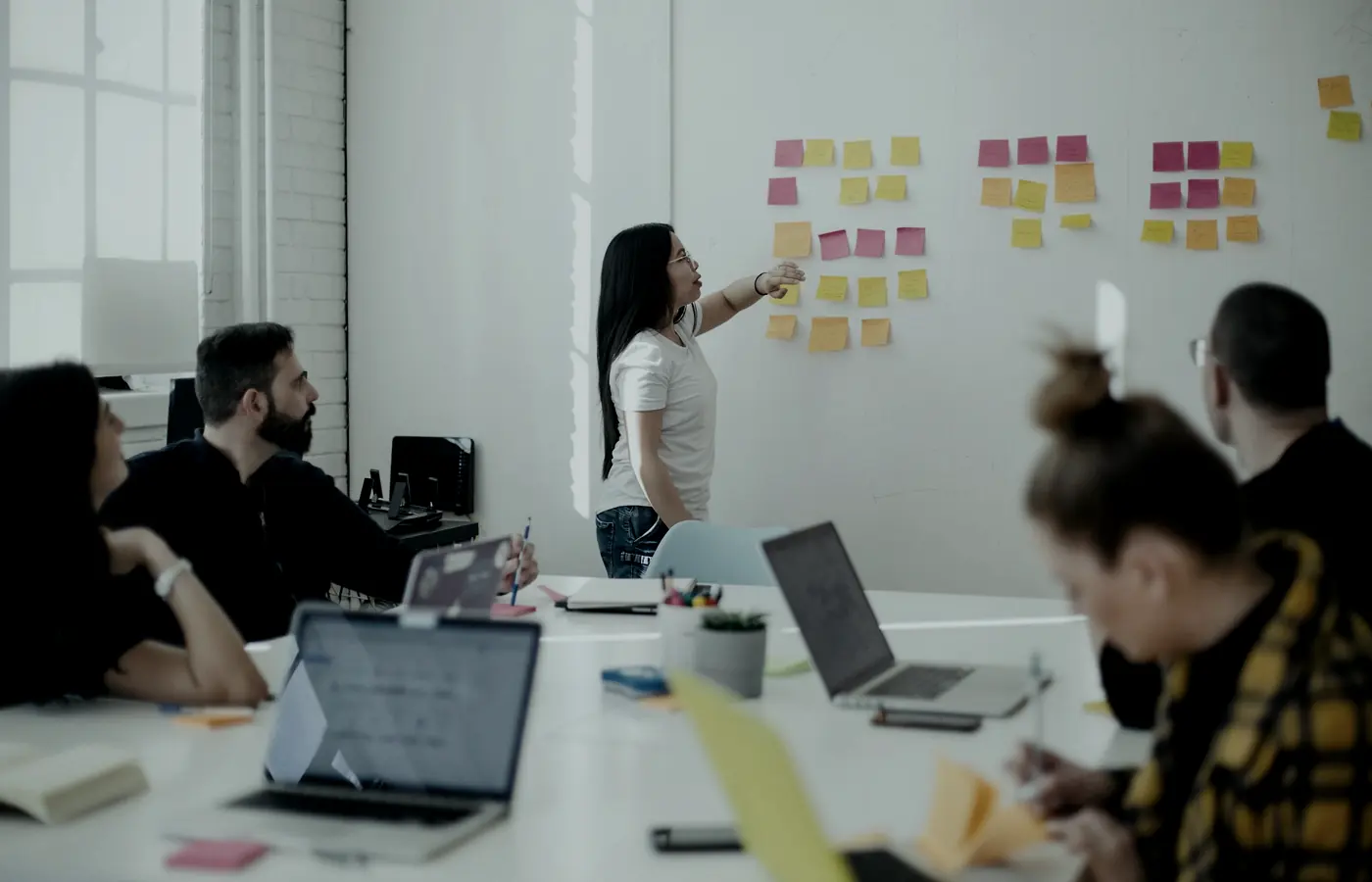 Un taller en marcha: una persona mapea un proceso en la pared mientras el equipo trabaja